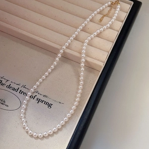 Close-up of freshwater pearl necklace with adjustable gold clasp in jewelry gift box
