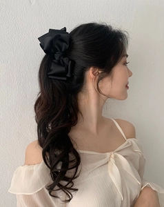 Eleganter großer Haarclip mit schwarzer Stoffschleife getragen an einem Frauenpferdeschwanz