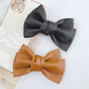 Handmade faux leather bow accessories in black and caramel with litchi grain texture