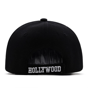 Black baseball cap with white Hollywood embroidery on adjustable back strap