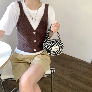 Detailed shot of zebra pattern handbag with LOVE SOZAKKA label and brown knit vest