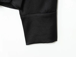 Dettaglio del polsino della camicia in raso nero che mostra texture e cuciture