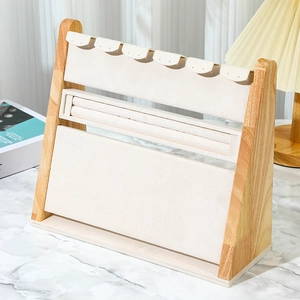 Detail view of wood jewelry display stand with beige velvet lining and necklace hooks
