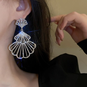 Close-up of model wearing silver fan-shaped earrings with shimmering crystals