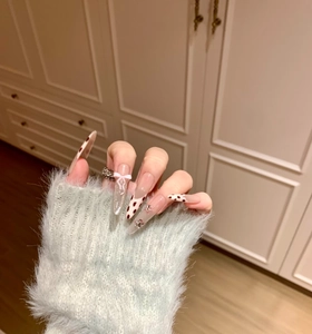 Gros plan d'ongles à presser à motif vache avec nœud 3D et paillettes argentées