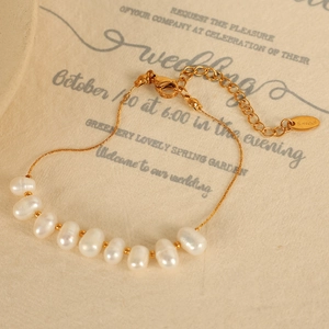 Bracelet doré en acier inoxydable avec neuf perles baroques blanches sur carte de mariage