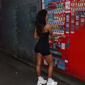 Street style shot of a slim fit black square neck jumpsuit on a model at night