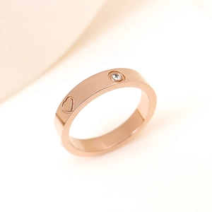 Detailed close-up of rose gold ring featuring a heart pattern and a sparkling zircon stone