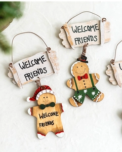 Detail of wooden Christmas gingerbread man welcome signs with festive hand-painted patterns