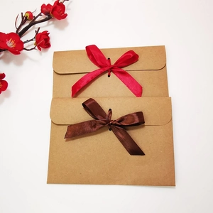 European vintage kraft paper envelope with decorative red and brown ribbon bows