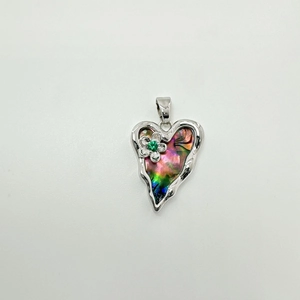 Detailed view of silver heart pendant featuring a small flower with a green gemstone inlay