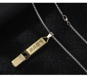 Close-up of vintage bronze whistle pendant with LOVE engraving on silver box chain