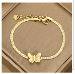 Detail of a vintage golden snake chain bracelet with a polished butterfly pendant