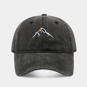 Macro detail of mountain peak embroidery on washed cotton charcoal baseball cap
