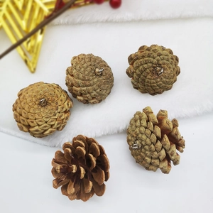 Detail of natural white-painted pine cones with metal hangers on white faux fur background