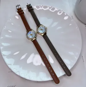 Detail of elegant quartz watches with rhinestone bezel and leather straps in a dish