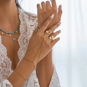 Détail du bracelet bague doré avec pompon en maille et anneau coeur sur le mannequin