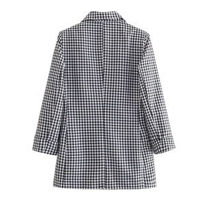 Back view of a classic black and white checkered blazer with stylish rolled sleeves