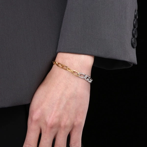 Two-tone silver and gold stainless steel mixed chain bracelet worn with a suit