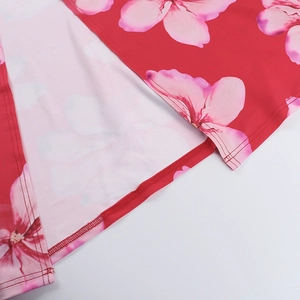 Detail of red dress hem showing pink floral patterns and high-quality double-stitch sewing
