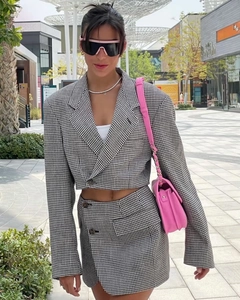 Photo de rue en extérieur d'une femme portant un ensemble tailleur pied-de-poule