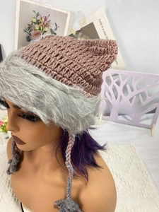 Detail of hand-knitted cat ear hat featuring pink crochet top and grey faux fur brim