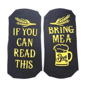 Detail of black non-slip socks with yellow text IF YOU CAN READ THIS BRING ME A BEER