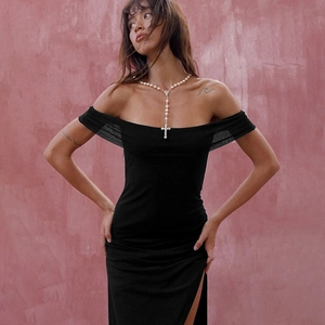 Close-up of sexy off-shoulder mesh dress with high slit detail on a slim fit black gown