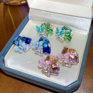 Close-up of 18k gold plated butterfly stud earrings set with colorful crystals and pearls