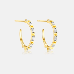 Macro detail of gold plated S925 silver C-shape earrings with baguette cut zircons