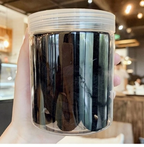 Detail of multi-pack high-elastic black seamless hair ties in a clear cylindrical jar