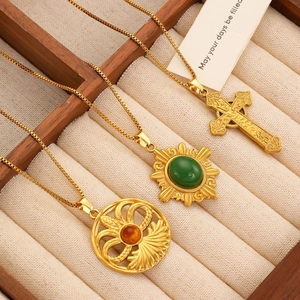 Detail view of retro gold necklaces with cross and gemstone pendants in a jewelry box