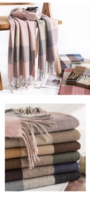 Close-up of stacked plaid scarves showing soft cashmere texture and fringe detail