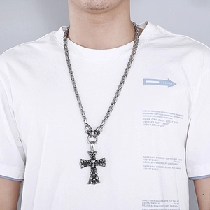 Detail of silver skull cross pendant on a keel chain worn by a male model