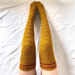 Close-up of ginger yellow knit thigh high socks with wavy texture and red striped cuffs