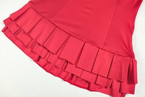 Detailed view of layered ruffle design and textured pleats on a red sleeveless mini dress