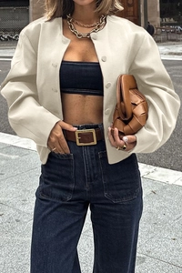 Close-up of minimalist cream white cropped jacket with smooth faux leather texture