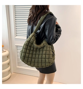 Detail of army green quilted puffer bag featuring soft rhombus texture and wide strap