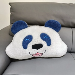 Close-up of soft blue panda plush pillow with detailed embroidery on a leather sofa