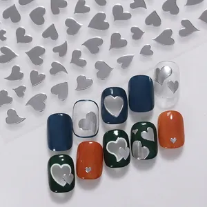 Silver metallic heart nail stickers applied on various colored nail art samples