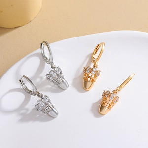 Gros plan de boucles d'oreilles volant de badminton en argent et or avec zircons