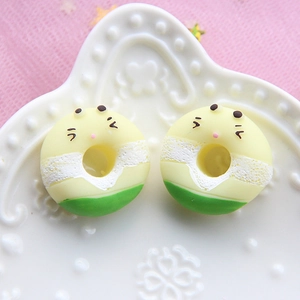 Macro shot of colorful resin donut charms with cute expressions in a ceramic dish