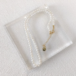 Close-up of small natural freshwater pearl necklace with adjustable gold-tone clasp