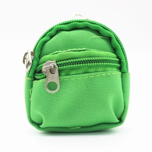 Close-up of green canvas mini backpack keychain featuring durable zippers and metal rings