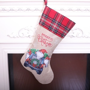 Linen Christmas stocking with red truck and Santa Claus hanging on white fireplace
