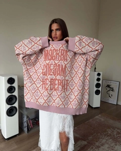 Detail of pink and white oversized knit sweater featuring bold red Cyrillic text embroidery
