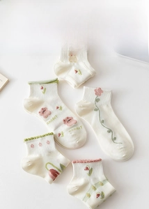 Detail of white cotton socks with pink tulip and rabbit embroidery and ruffled cuffs