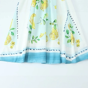 Poplin dress with lemon print and blue watercolor hem detail on a light background