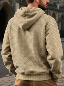 Detail of men's beige textured hoodie featuring a diamond knit pattern and ribbed hem