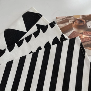 Detail of woven canvas placemats with minimalist black and white geometric patterns